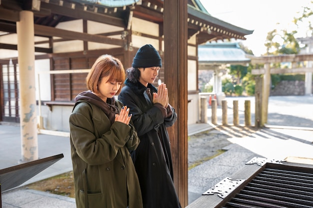 Free Photo japanese couple praying in temple while on a date