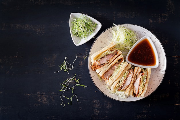 Free photo japanese sandwich with breaded pork chop, cabbage and tonkatsu sauce.