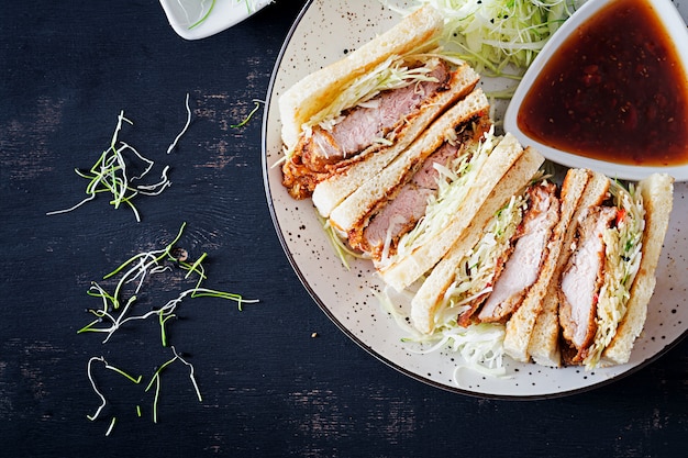 Free photo japanese sandwich with breaded pork chop, cabbage and tonkatsu sauce