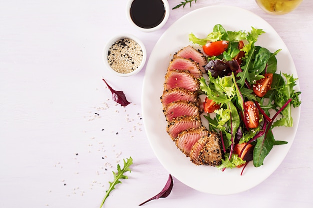 Free Photo japanese traditional salad with pieces of medium-rare grilled ahi tuna and sesame with fresh vegetable salad on a plate