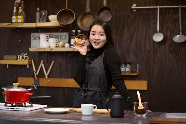 Japanese woman posing while holding a doughnut