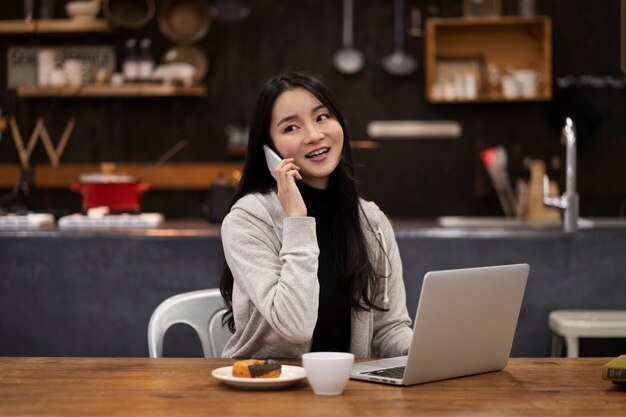 Japanese woman talking on her smartphone while working in a restaurant