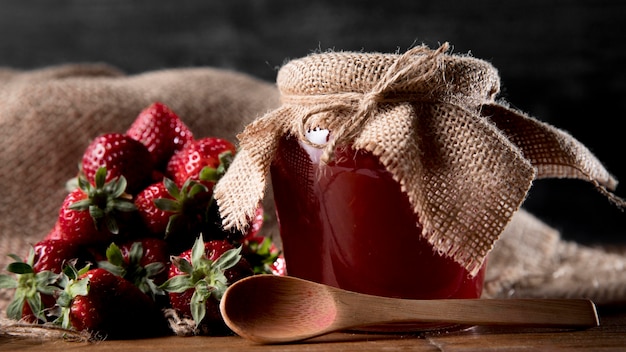 Jar with strawberry jam and spoon