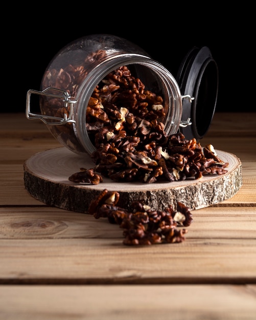 Free Photo jar with walnuts on wooden board