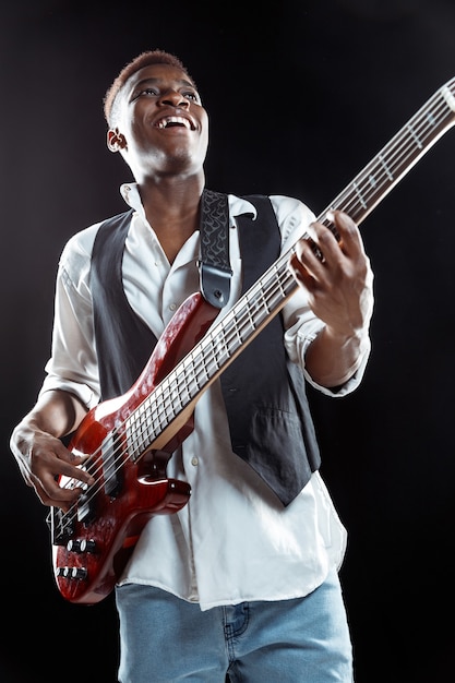 Free Photo jazz musician playing bass guitar in the studio on a black wall