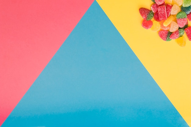 Jelly candies on colorful triangular background