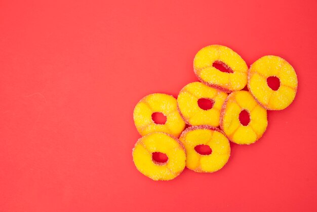 Jelly fruits circle cut on red table 