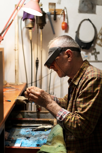 Free photo jewelry maker working alone in the atelier