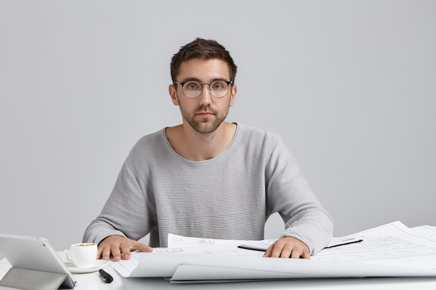 Free photo job, modern technologies, creativity and occupation concept. picture of handsome young male engineer with trimmed beard