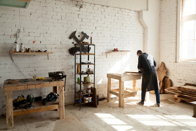 Free Photo joiner working at workbench in small carpentry