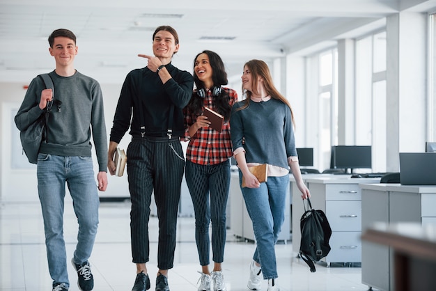 Joking around. Group of young people walking in the office at their break time