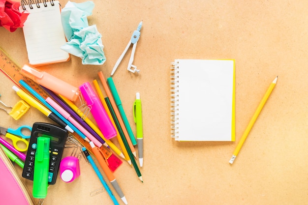 Jotter with pencil and writing implements laid in random way