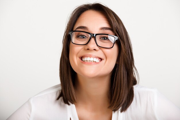 Joyful adult woman in glasses, smiling toothy