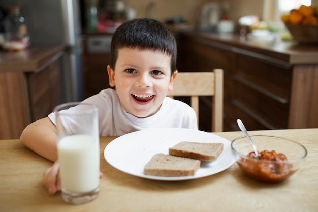 Free photo joyful boy playing around while eating