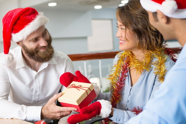 Joyful business colleagues exchanging gifts