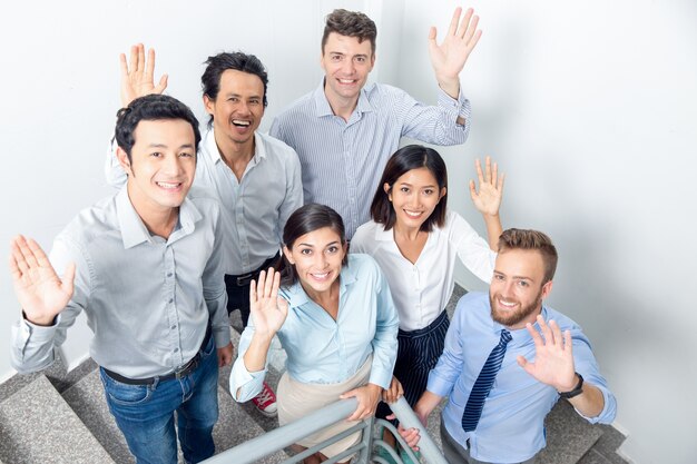 Joyful Business Team Waving on Office Stairway