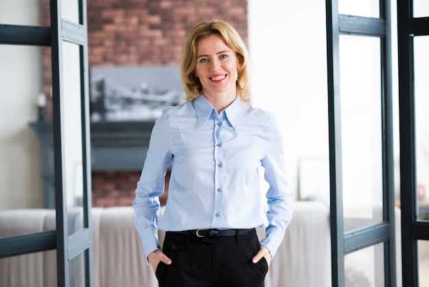 Free Photo joyful business woman holding hands in pockets