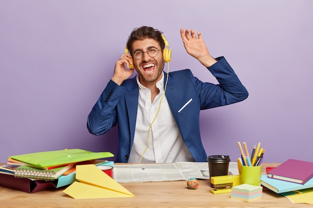 Joyful businessman sitting at the office desk