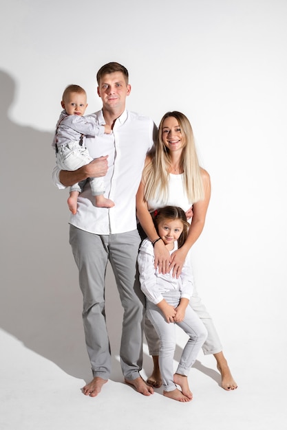 Joyful Caucasian family with two children in studio.