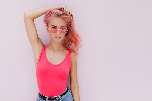 Joyful caucasian woman with pink hair posing with cute smile.