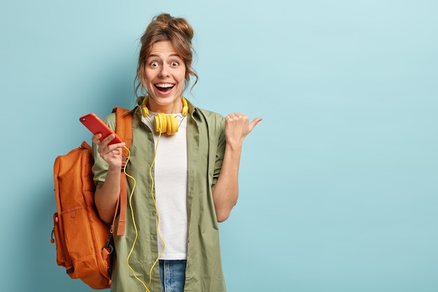 Joyful European girl checks nootification or email box on cellular