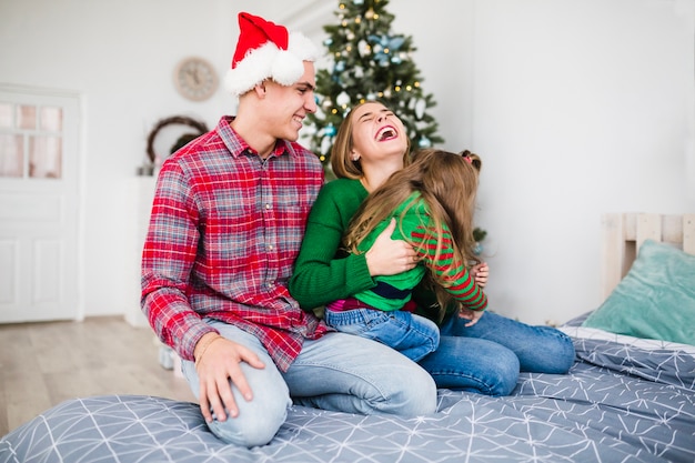 Joyful family on bed at christmas