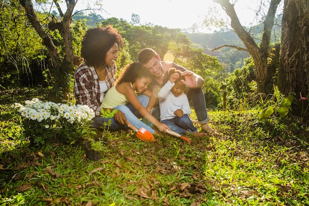 Free photo joyful family sitting in grass