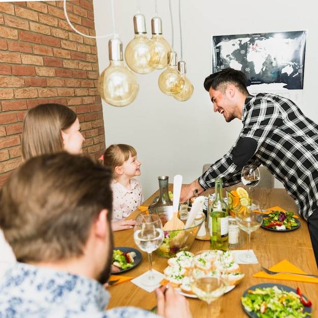 Free photo joyful family sitting at the table