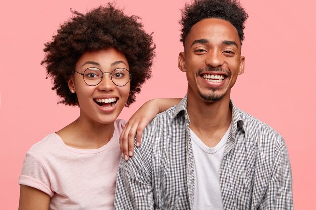 Joyful friends being in good mood after noisy party with friends, stand closely, smile broadly