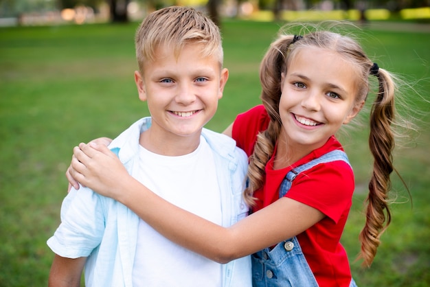 Joyful girl embracing boy in park