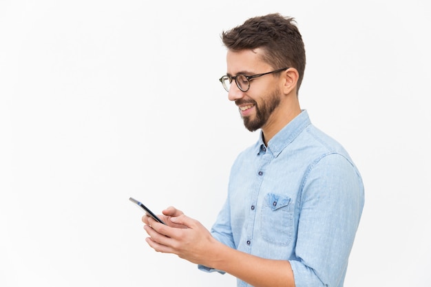 Joyful guy texting message on smartphone