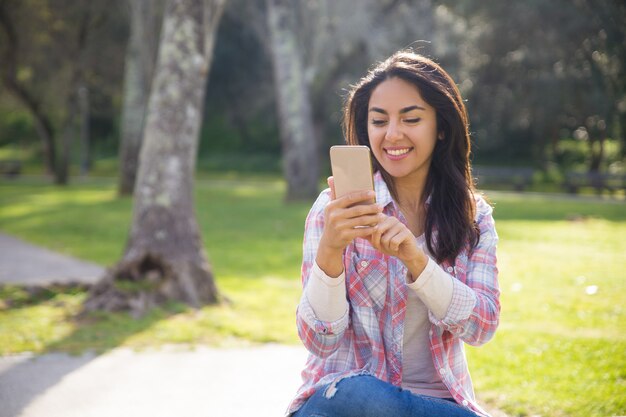 Joyful hipster girl happy to use wireless connection in part