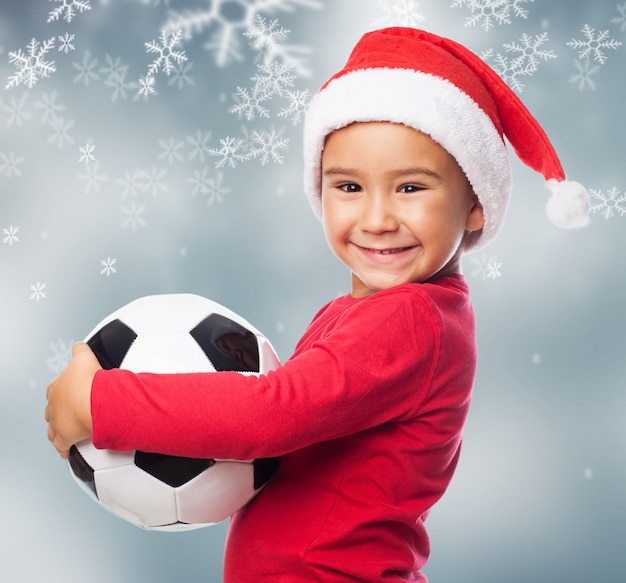 Joyful little boy giving a hug to his ball