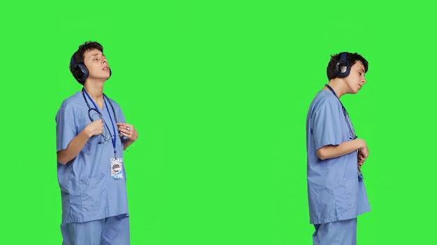 Joyful nurse singing and dancing with wireless headphones on