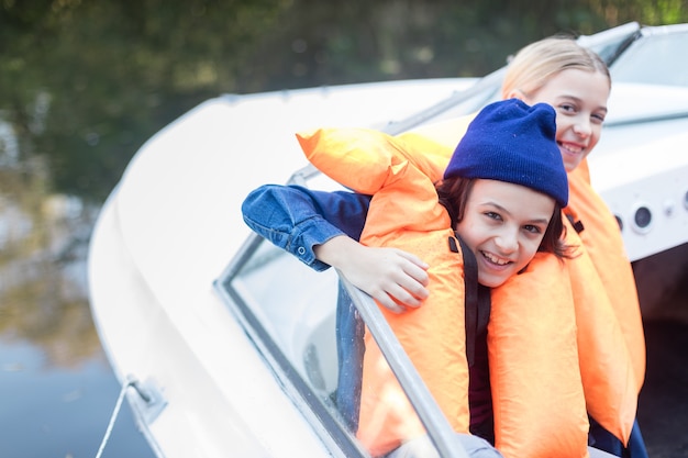 Free Photo joyful siblings enjoying a boat ride