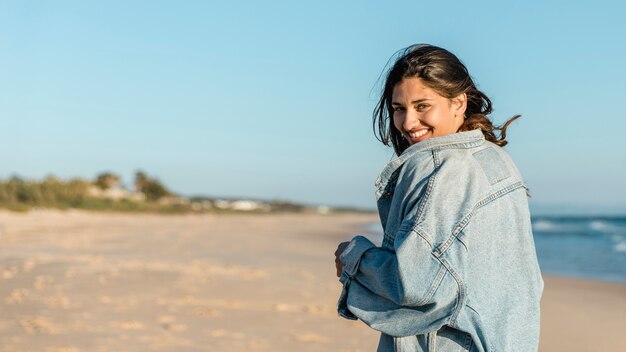 Joyful woman on beach looking over shoulder