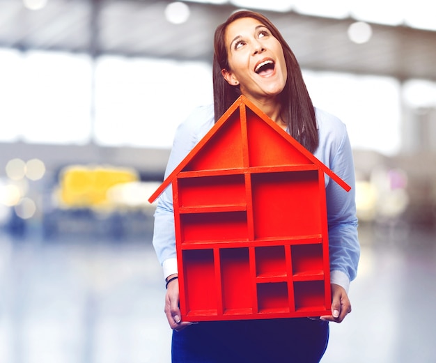 Free Photo joyful woman holding a wooden house