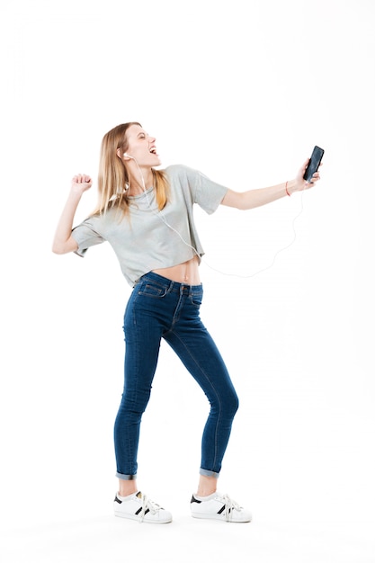 Joyful woman listening music and dancing