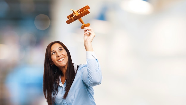 Joyful woman playing with a toy plane