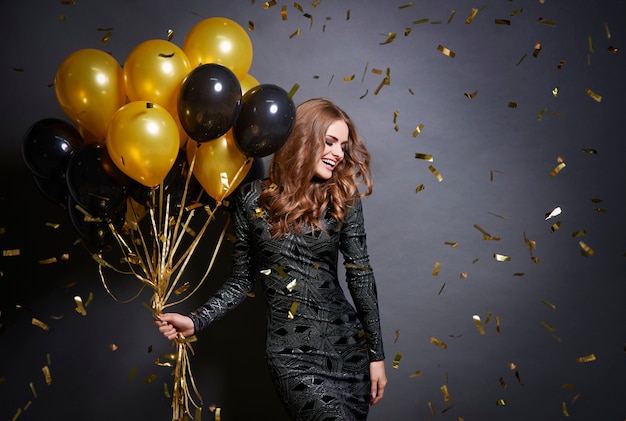 Joyful woman with bunch of balloons 
