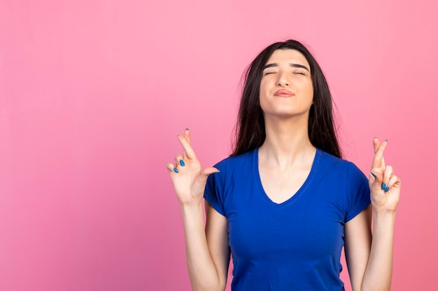 Joyful young lady holding her fingers together and feeling happy High quality photo