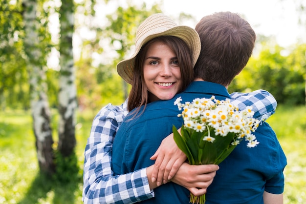 Free photo joyful young woman embracing boyfriend in park