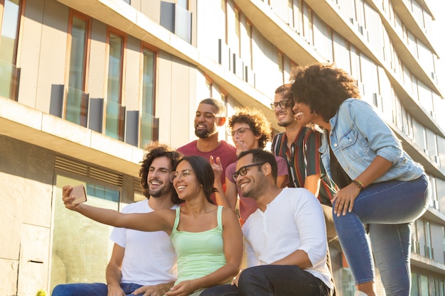 Joyous happy multiethnic friends taking group selfie