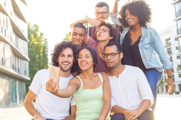 Joyous mix raced people taking group selfie