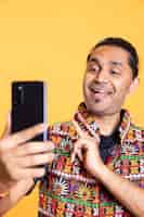 Free photo joyous narcissistic man using cellphone to take selfies