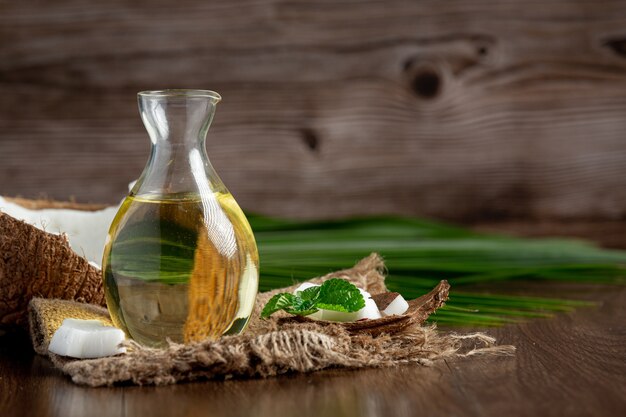 jug of coconut oil whit coconut put on dark background