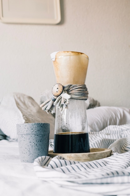 Jug with filter and cup on bed