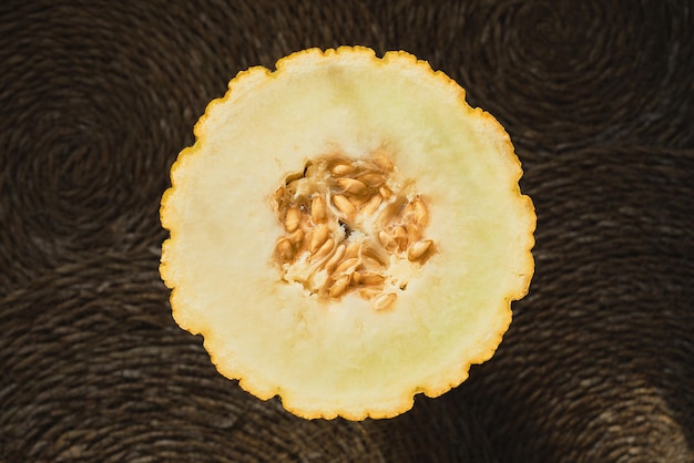 Juicy melon cut in half on a straw deck top view organic fruit advertising idea from a local farmer's market Healthy seasonal food article background or concept