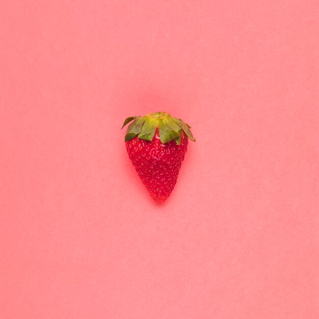 Juicy red strawberry on pink background