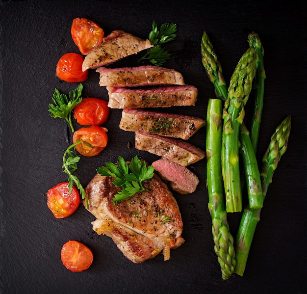 Free photo juicy steak medium rare beef with spices and tomatoes, asparagus. top view